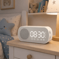 Enceinte radio réveil Bluetooth blanche posée sur la table de nuit d’une chambre d’enfant